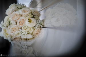 A bouquet of white roses is sitting on a table at a wedding.