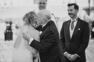 A bride kisses her father during a wedding ceremony at Loews Hotel Philly.