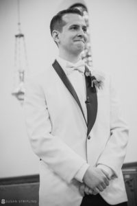 A black and white photo of a groom at a wedding, dressed in a tuxedo at the Florentine Gardens estate.