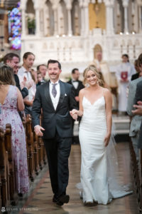A wedding couple walking down the aisle of a church.