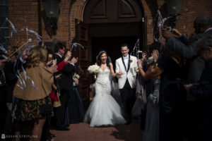 A wedding couple exiting a church with confetti.
