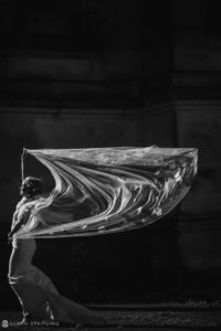 A black and white photo of a woman with a veil at a wedding.