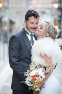 A bride and groom kissing on the street during their wedding in Chicago.