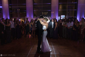 At the Loews Hotel Philly, a bride and groom are gracefully sharing their first dance at their lavish wedding reception.