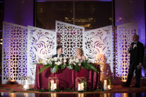 A bride and groom sitting at a table at a wedding reception at Loews Hotel Philly.