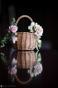A wedding basket with flowers sitting on top of a table at Whitby Castle.