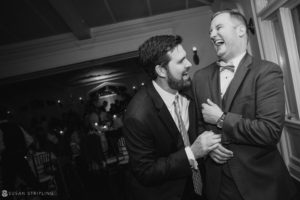 Two men laughing at a Whitby Castle wedding reception.