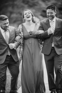 A black and white photo of a group of people laughing at a wedding at Stonover Farm.