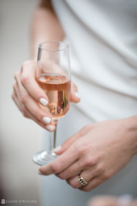At a beautiful wedding ceremony at Stonover Farm, a woman elegantly holds a glass of wine, savoring the celebratory atmosphere.