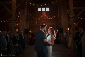At the beautiful Stonover Farm, a bride and groom gracefully share their first dance in a charming barn.