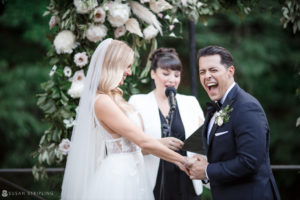 A bride and groom laughing during their New York wedding ceremony.