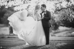 A bride and groom standing under a tree in a black and white photo at the New York Botanical Gardens.