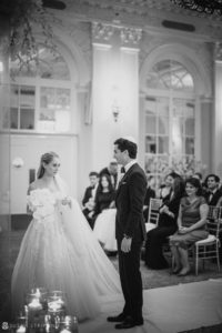 A bride and groom standing in front of an ornate wedding ceremony held at the Yale Club.