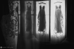 A black and white photo of wedding dresses hanging in the window of a Philadelphia bridal shop.