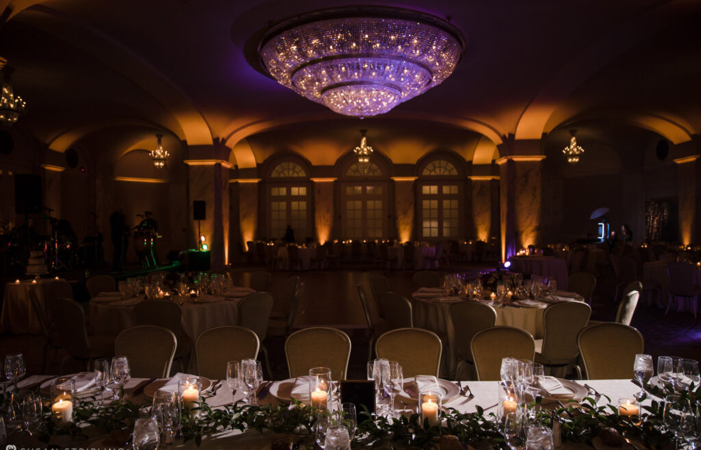 A wedding reception at the Ritz Carlton Philadelphia set up with elegant candles and sparkling chandeliers.