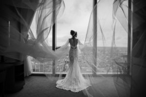 A beautiful bride is standing in front of a window with a veil at the Four Seasons Hotel Philadelphia at Comcast Center Wedding.