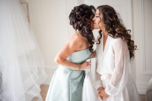 A bride kisses her mother in her wedding dress at The Estate at Florentine Gardens.