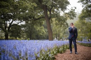 A man in a suit standing in a field of bluebells at the Brooklyn Botanic Garden.
