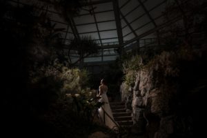 A bride is standing in the Brooklyn Botanic Garden on a rainy summer wedding night.