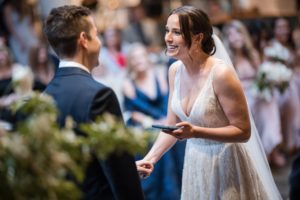 A bride and groom smiling at each other during their rainy summer wedding ceremony at the Brooklyn Botanic Garden.