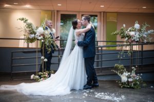 A bride and groom kiss during their rainy summer wedding at the Brooklyn Botanic Garden.