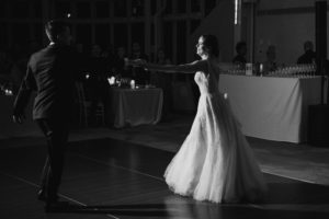 A bride and groom dancing at a rainy summer wedding reception.