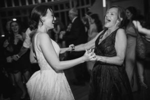 A bride and her mother dancing at a rainy summer wedding in the Brooklyn Botanic Garden.