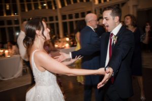 A bride and groom dancing at their summer wedding reception at Brooklyn Botanic Garden.