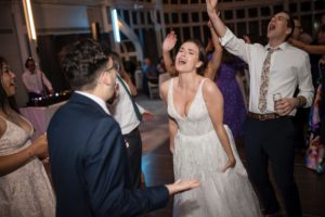 A bride and groom dancing at a summer wedding reception.