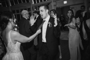A bride and groom dancing at a summer wedding reception.