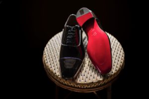 A pair of red and black shoes sitting on a wicker chair at Liberty Warehouse.