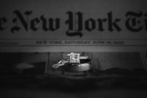 A wedding ring sits on top of the New York Times newspaper at Bourne Mansion, a summer wedding venue.
