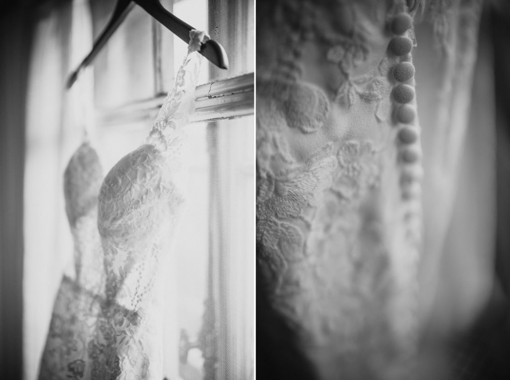 A summer wedding dress hanging on a window, captured in a black and white photo.