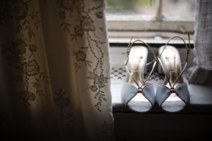 A pair of blue wedding shoes sitting on a window sill at Bourne Mansion.