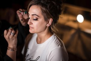 A woman getting her makeup done by a wedding makeup artist in NYC at Capitale.