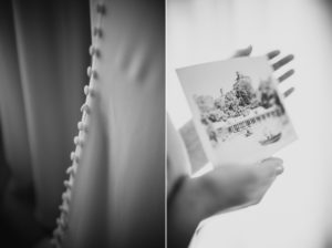 A black and white photo of a woman holding a wedding photo at the Wallace and Loeb Boathouse.