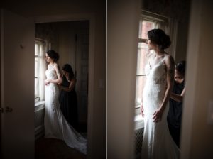 A bride is getting ready in front of a window at Bourne Mansion for her summer wedding.