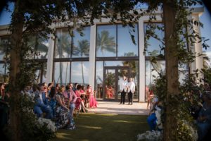 A wedding ceremony at the Ritz Carlton in Dorado Beach, surrounded by palm trees.