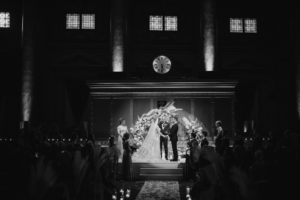 A black and white photo capturing the elegance of a wedding ceremony in a NYC church.