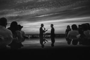 A black and white photo of a couple at sunset during their wedding.