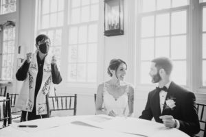 Summer wedding photo of a bride and groom at a table at Bourne Mansion.