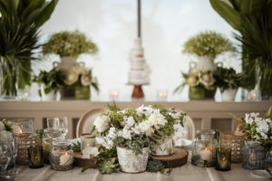A table set with white and green flowers and candles at a wedding at the Ritz Carlton in Dorado Beach.