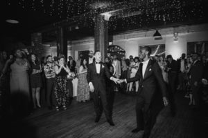 A black and white photo of two men dancing at a Summer wedding at the Liberty Warehouse.