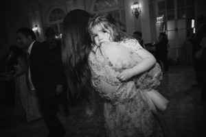 A woman is hugging a little girl at a wedding at St. Francis Xavier.