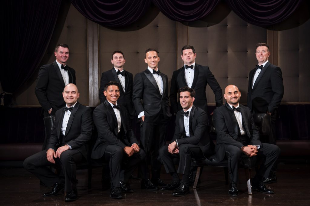 A group of men in tuxedos posing for a wedding photo at Capitale in NYC.