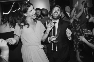 A couple gracefully dancing at a summer wedding reception.