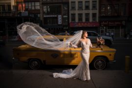 A bride poses in front of a yellow taxi in Capitale, NYC.
