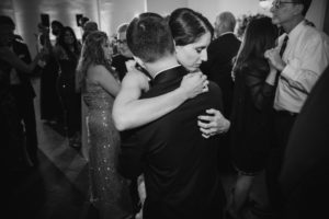 A bride and groom hugging at a summer wedding reception at Bourne Mansion.