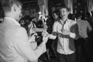 A black and white photo of a group of people dancing at a wedding at the Ritz Carlton.