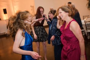 Two women dancing at a wedding reception held in the Bourne Mansion.